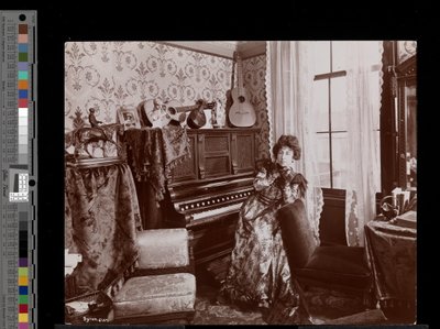 Anita Chartres sitting at a player piano, c.1898 by Byron Company